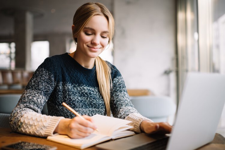 Junge Studentin sitzt am Laptop